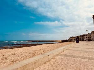 a sandy beach next to the ocean on a cloudy day at Villa Bahia Golf beach - Bouznika in Casablanca