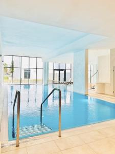 duży basen z błękitną wodą w budynku w obiekcie LET'S SEA - 4 Person - Premium Baltic Apartment with Sea View nad SPA access w Gąskach