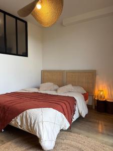 une chambre avec un lit avec une couverture rouge dans l'établissement Studio équipé Clim jardin Spa Centre Arles à 10mn, à Arles