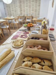 a table with boxes of pastries and plates of food at Casa Jazmin by Blossom Hotels in Granada