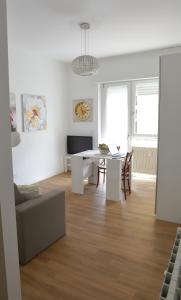 a white living room with a table and a couch at Valeria Apartment in Monza +17 photos