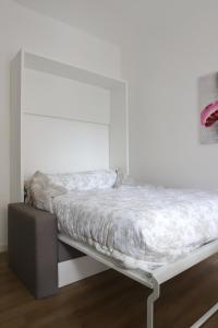 a bed in a room with a white wall at Valeria Apartment in Monza