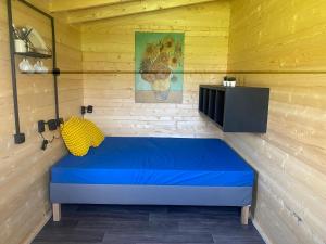 Camera con letto blu e TV di Woodland Cabin Camping de Regenboog a Šluknov