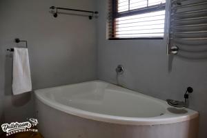 a white bath tub in a bathroom with a window at Cherry Grove 3 in Dullstroom +11 photos