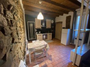 a kitchen with a table and a stone wall at Il Fiore nascosto in Bergamo