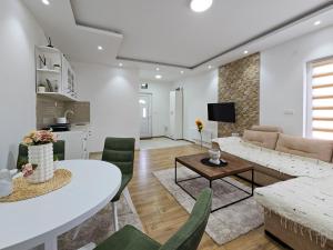 a living room with a couch and a table at Zlatni bor apartmani in Solotuša