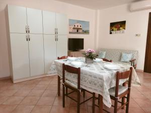 a dining room with a table and chairs and a tv at Casa Giuliana in Pula +6 photos