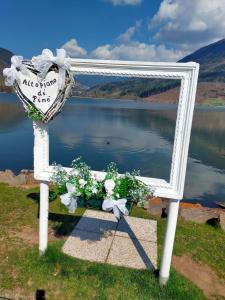 a mirror sitting on the grass next to a lake at Casa Anelis in Bedollo