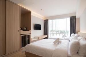 a bedroom with a large white bed with a large window at BEAT Warii Hostel at Chaophraya River in Bangkok