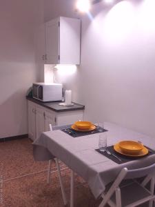 a table with two yellow plates and a microwave at Casa di Alby in Rapallo
