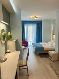 Pokój hotelowy z łóżkiem, biurkiem i pokojem w obiekcie Hotel Négy Évszak w Hajduszoboszlo