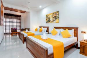 a bedroom with two beds with yellow and white at Ark Cabin Villa in Kandy