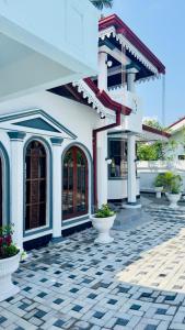 a white building with a black and white tiled courtyard at Yahana Beach Villa in Negombo