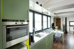 莱茵河畔阿尔芬Aangenaam op de Rijn, woonboot, inclusief privé sauna的带水槽和炉灶的厨房