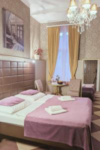 1 dormitorio con 2 camas, mesa y lámpara de araña en Hotel Pension Bella, en Berlín