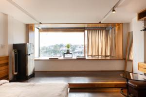 Xuan AnにあるPha boutique houseの窓、冷蔵庫、テーブルが備わる客室です。