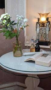 una mesa con un jarrón de flores y un libro en Hotel Pension Bella, en Berlín