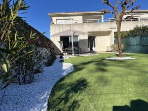 una casa con un patio de césped con un árbol en Appartement jardin à deux pas de la mer Classé 3 étoiles, en Poggio-Mezzana 16 fotos más