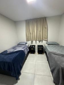 a bedroom with two beds and a window at Apartamento completo em Salinópolis in Salinópolis +9 photos