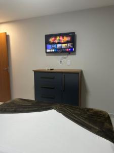 a bedroom with a bed and a tv on the wall at Apartamento completo em Salinópolis in Salinópolis