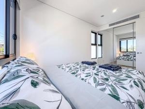 a bedroom with a large bed with a floral bedspread at Brand New 3 bedrooms townhouse in North Paramatta in Sydney
