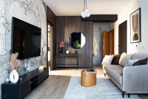 a living room with a couch and a tv at Park Vista in Szczecinek