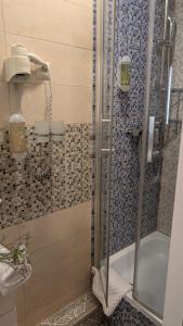 Un baño con ducha con puerta de cristal. en Hotel Pension Bella, en Berlín 81 fotos más