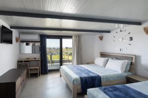 a hotel room with two beds and a clock on the wall at Villa Miranda Roshi in Toroni