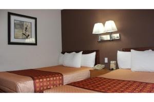 a hotel room with two beds and a phone at Travel Inn By OYO Omaha in Millard +16 photos