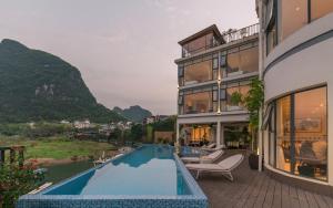 a house with a swimming pool next to a building at Xitang River View Holiday Motel in Yangshuo