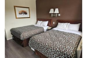 a hotel room with two beds and a picture on the wall at Travel Inn By OYO Omaha in Millard