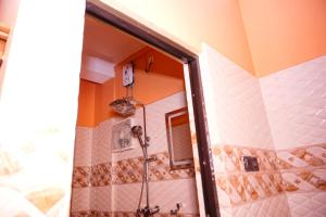 eine Dusche im Bad mit Spiegel in der Unterkunft VictoriaPalace in Colombo