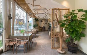 a restaurant with tables and chairs and a potted plant at Xitang River View Holiday Motel in Yangshuo