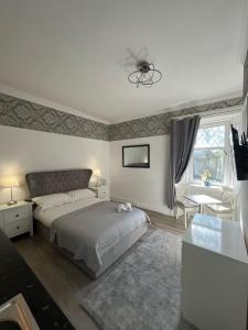 a bedroom with a bed and a table and a window at Bemersyde Guest House in Mansewood