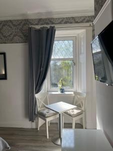 a dining room with a table and a window at Bemersyde Guest House in Mansewood