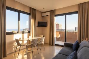 a living room with a couch and a table and chairs at Ollen apartments in Catania