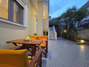 a wooden table and chairs on a patio at Villa Alexandros in Pogradec