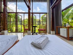 a bedroom with two beds and a large window at NernJamsai in Sop Poeng
