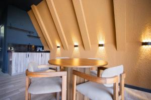 a dining room with a wooden table and chairs at Aynur Forest A-Frame Houses in Quba