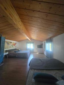 a large room with two beds and a wooden ceiling at Chambre familiale "le pêcher" in Saillans +32 photos