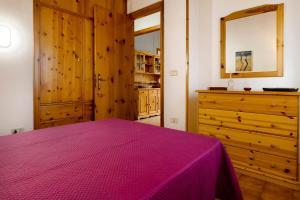 a bedroom with a purple bed and a dresser at Villa con piscina a due passi da Siracusa in Canicattini Bagni +29 photos