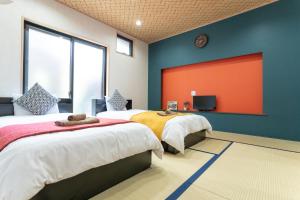 two beds in a room with a red wall at nestay東九条01左側 in Kyoto +25 photos