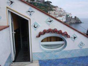 a building with a clock on the side of it at Holidays Baia D'Amalfi in Amalfi