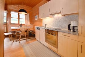 a kitchen with white cabinets and a dining table at Haus Albrecht in Schoppernau