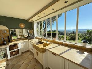 a kitchen with a large window with a view at Villa Notre-Dame avec piscine in Rochefort-du-Gard