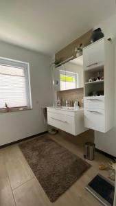 a white bathroom with a sink and a window at Ferienpark Worpswede in Worpswede