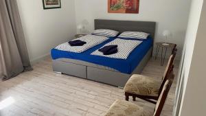 a bedroom with a bed with blue and white sheets and a chair at Ferienpark Worpswede in Worpswede