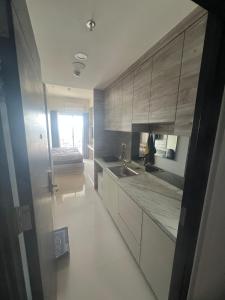 JodohにあるCitra plaza nagoya apartmentのキッチン(シンク付)、背景にベッド1台が備わります。