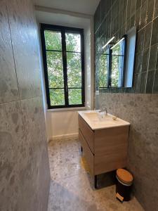 a bathroom with a sink and a window at Maison 1880 in Annonay