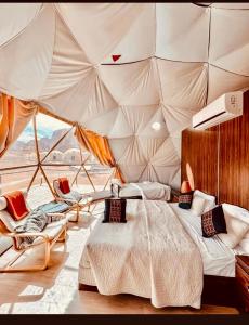 a bedroom in a tent with a bed and chairs at Angelina Luxury Camp in Wadi Rum